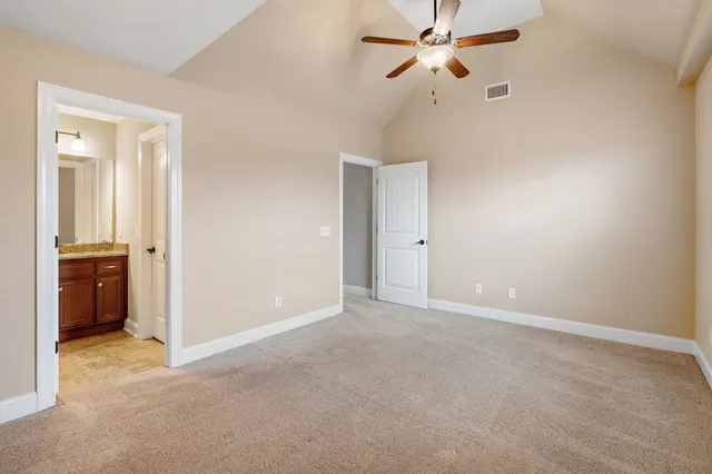 an empty room with closet and a ceiling fan