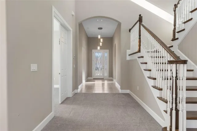 a large white kitchen with a refrigerator a kitchen island a stove and a sink