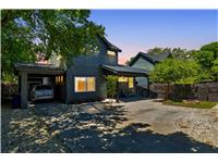 View of front of home featuring a shingled roof, fence, attached carport, and concrete driveway