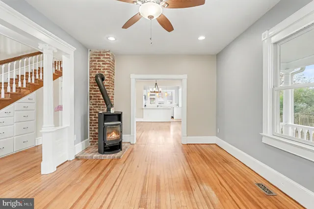 a view of an empty room with window and wooden floor