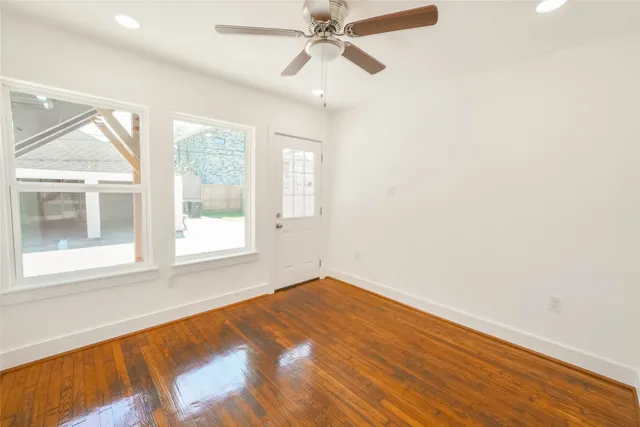 an empty room with a window and a ceiling fan