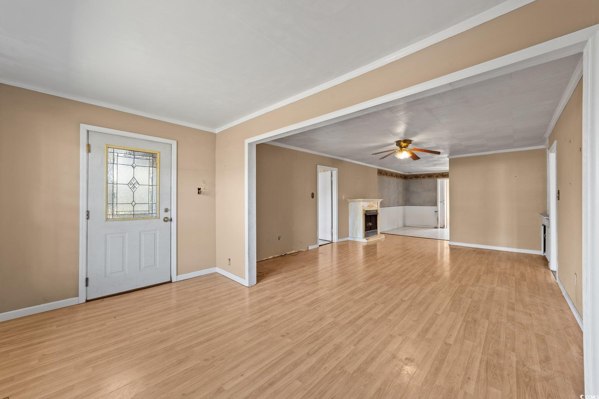 Unfurnished living room with crown molding, light