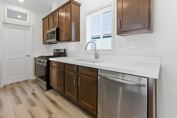 a kitchen with a sink stainless steel appliances and cabinets