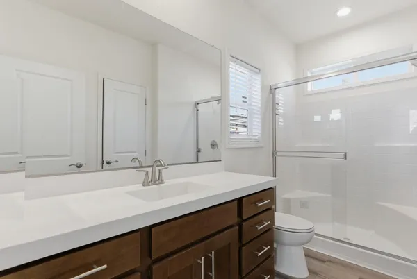 a bathroom with a sink a toilet a shower and a mirror