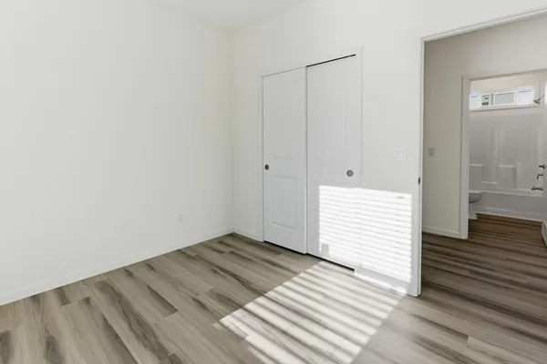 a view of a room with wooden floor and white walls
