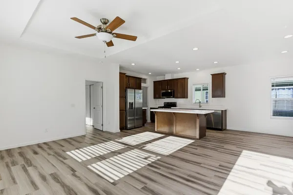 a open kitchen with stainless steel appliances kitchen island a refrigerator sink and fireplace