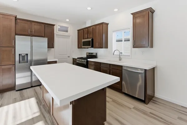 a large kitchen with a sink a microwave and refrigerator