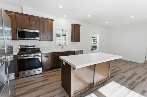 a kitchen with stainless steel appliances a stove microwave and sink