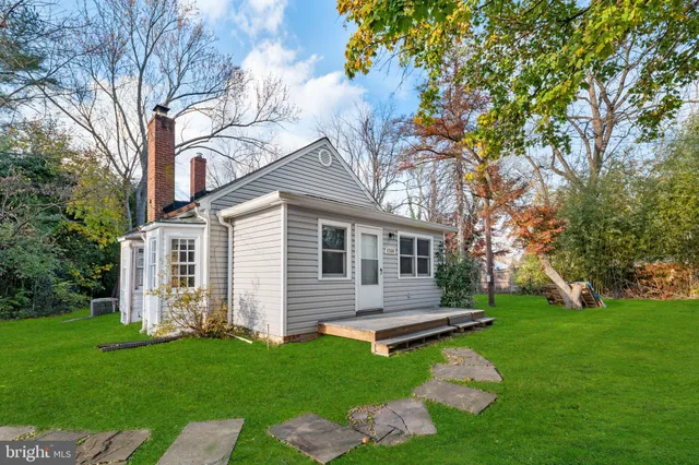 a front view of a house with a yard table and trees