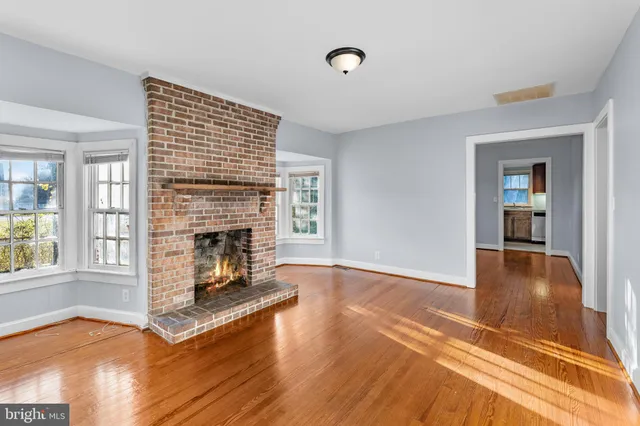 a view of a livingroom with wooden floor and a fireplace