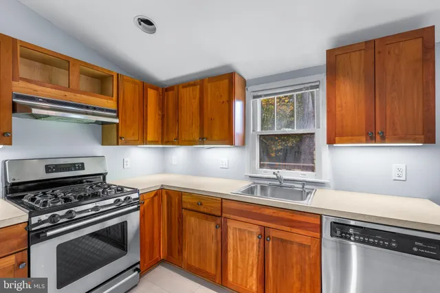 a kitchen with stainless steel appliances a stove sink and cabinets