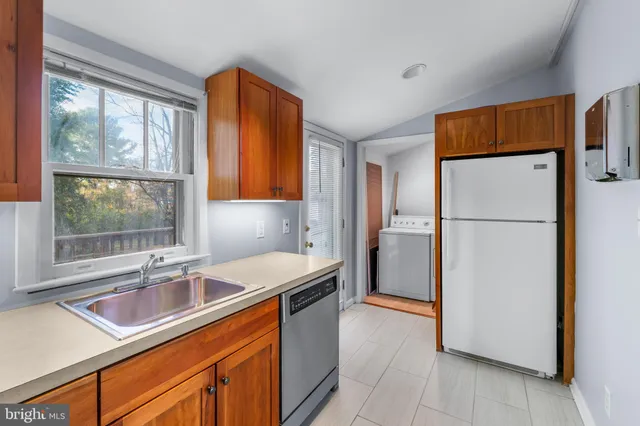 a kitchen with stainless steel appliances granite countertop a refrigerator and a sink