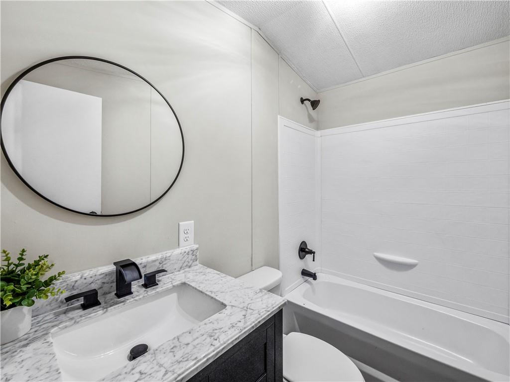 1458 Grant Mill Road Alto, GA 30510 - Photo 12 of 32 a bathroom with a granite countertop sink mirror toilet and bathtub