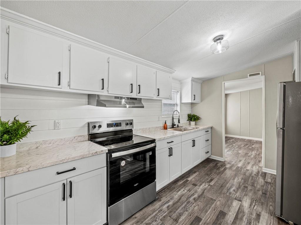 1458 Grant Mill Road Alto, GA 30510 - Photo 23 of 32 a kitchen with granite countertop white cabinets and white appliances