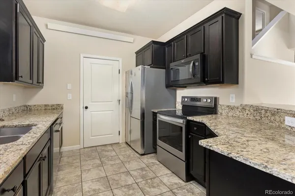a kitchen with stainless steel appliances granite countertop a refrigerator stove and oven
