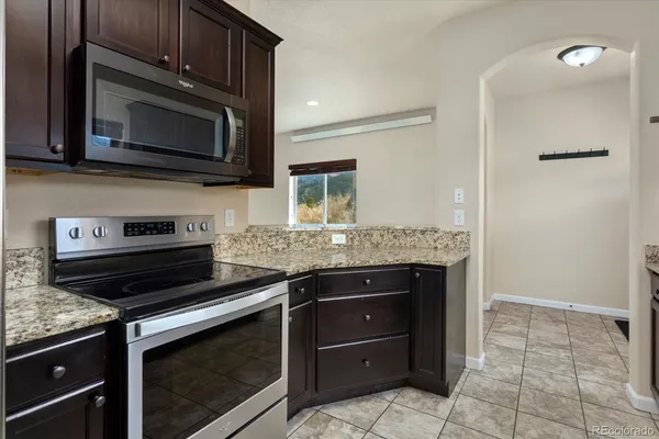 a kitchen with granite countertop a stove and a microwave