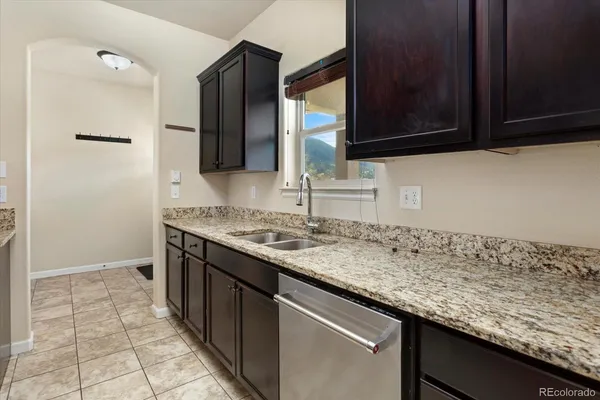 a kitchen with granite countertop a sink and a stove