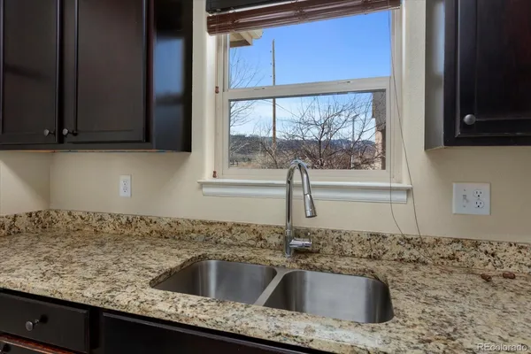a kitchen with granite countertop sink and cabinets