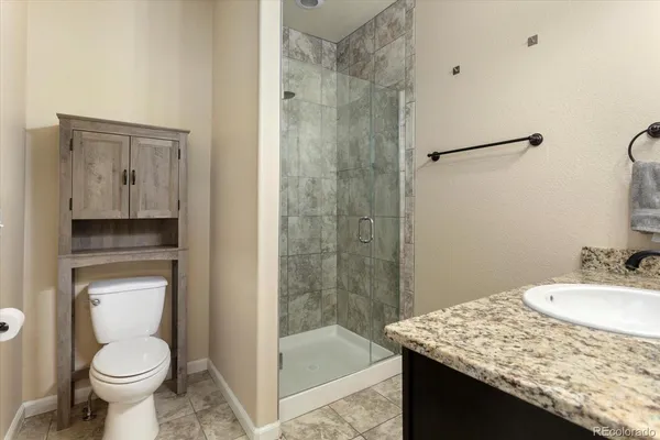 a bathroom with a granite countertop sink toilet and shower