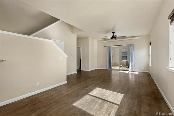 a view of a livingroom with wooden floor and staircase