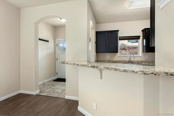 a view of a kitchen with a sink and wooden floor