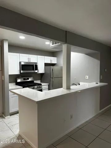 a kitchen with stainless steel appliances a sink a stove a microwave a sink a refrigerator and cabinets