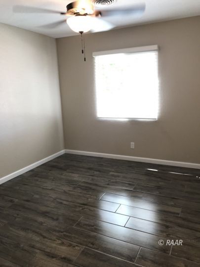 1352 Sydnor Avenue Ridgecrest, CA 93555 - Photo 12 of 26 an empty room with wooden floor and windows