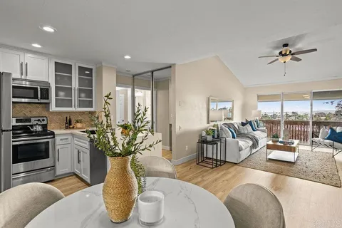 a kitchen with stainless steel appliances granite countertop a couch and a chandelier