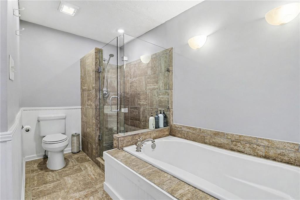 296 Fairview Court Jasper, GA 30143 - Photo 12 of 40 a spacious bathroom with a granite countertop toilet a sink and a bathtub