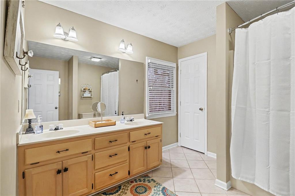 296 Fairview Court Jasper, GA 30143 - Photo 18 of 40 a spacious bathroom with a double vanity sink a mirror and a shower