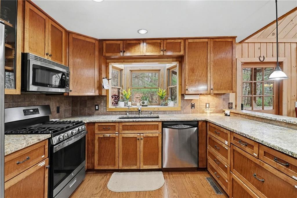 296 Fairview Court Jasper, GA 30143 - Photo 8 of 40 a kitchen with stainless steel appliances granite countertop white cabinets granite counter tops and a window