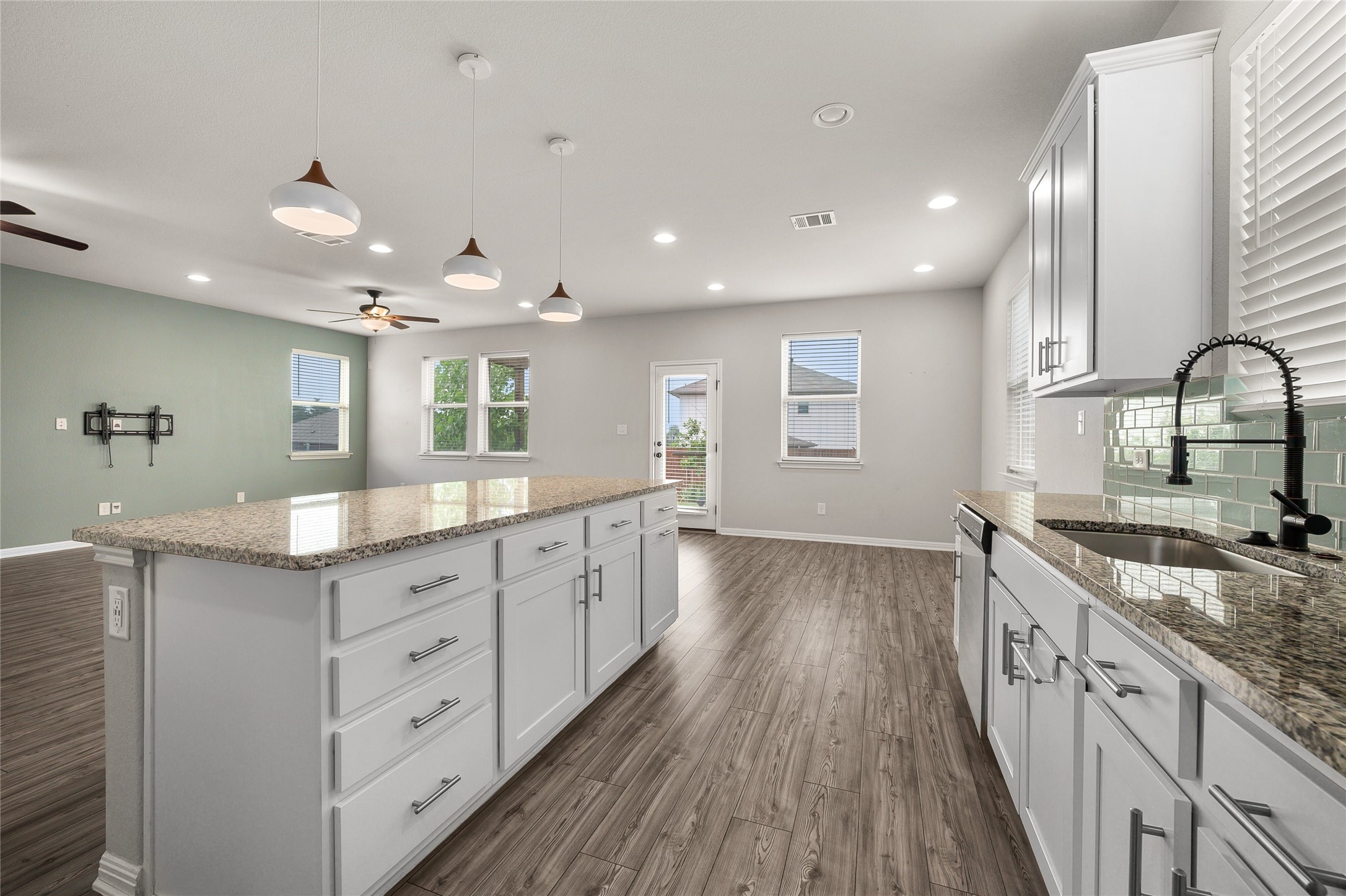 101 Lambert Street Leander, TX 78641 - Photo 10 of 33 A grand kitchen island with granite counters commands attention in this open-concept living space.