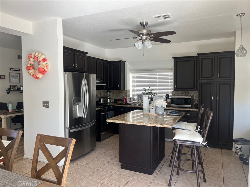 6105 Sherry Court Rancho Cucamonga, CA 91737 - Photo 11 of 35 a kitchen with a refrigerator a stove a sink and a cabinets