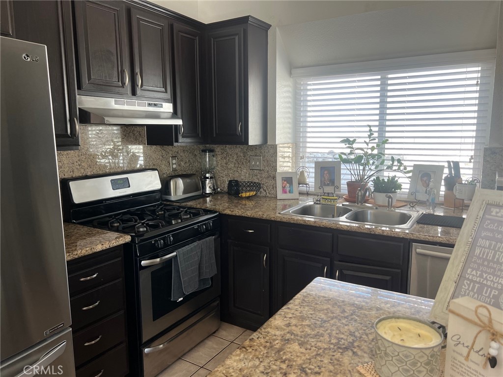 6105 Sherry Court Rancho Cucamonga, CA 91737 - Photo 12 of 35 a kitchen with stainless steel appliances granite countertop a stove a sink and a refrigerator