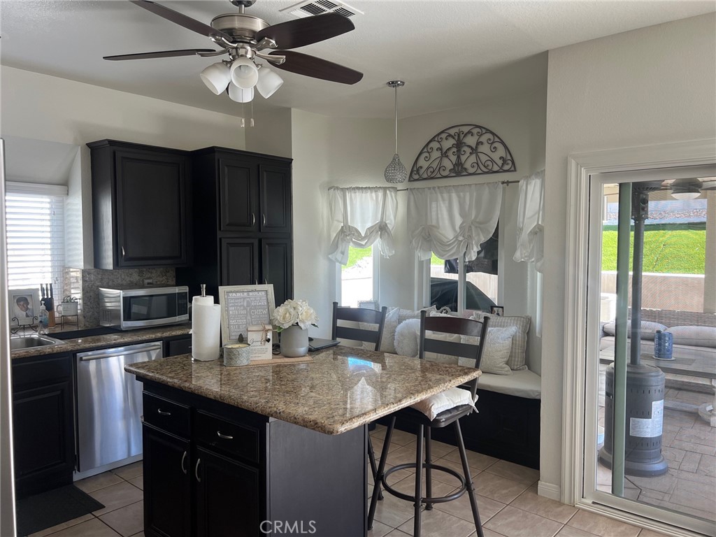 6105 Sherry Court Rancho Cucamonga, CA 91737 - Photo 17 of 35 a kitchen with a granite countertop sink cabinets and stainless steel appliances