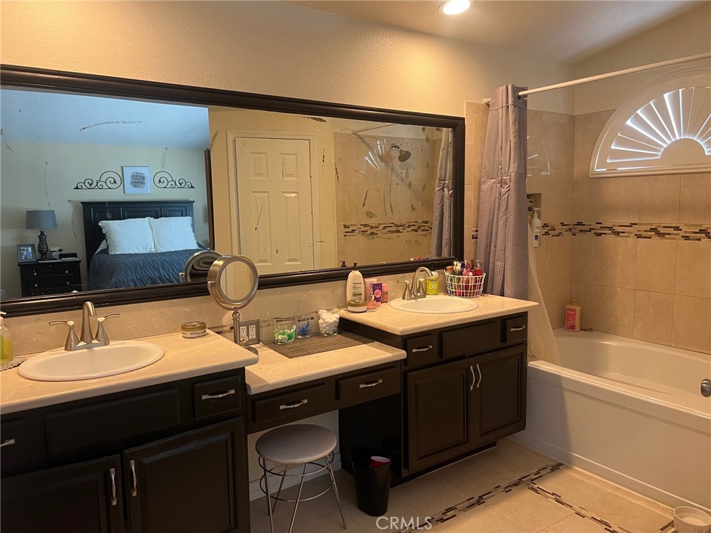 6105 Sherry Court Rancho Cucamonga, CA 91737 - Photo 24 of 35 a bathroom with a double vanity sink a mirror and a bathtub