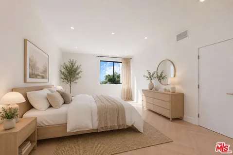 a bedroom with bed and white cabinets
