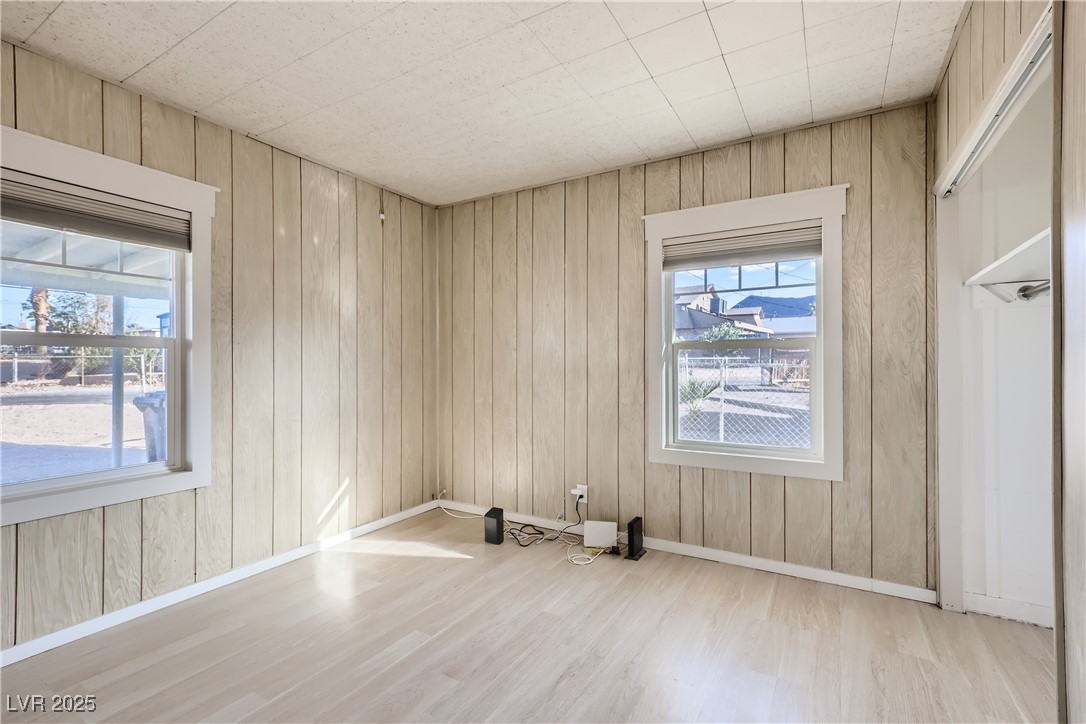 103 West Victory Road Henderson, NV 89015 - Photo 20 of 28 Empty room featuring light wood-style floors, baseboards, and wood walls