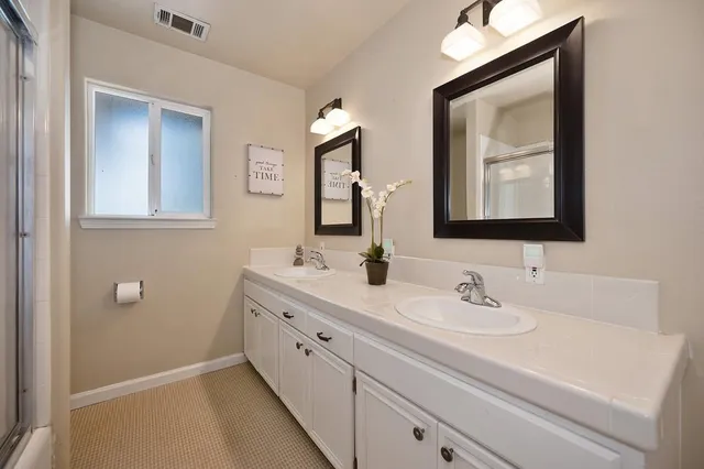 a bathroom with a double vanity sink and mirror