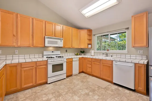 a kitchen with stainless steel appliances granite countertop a stove a sink dishwasher and a refrigerator