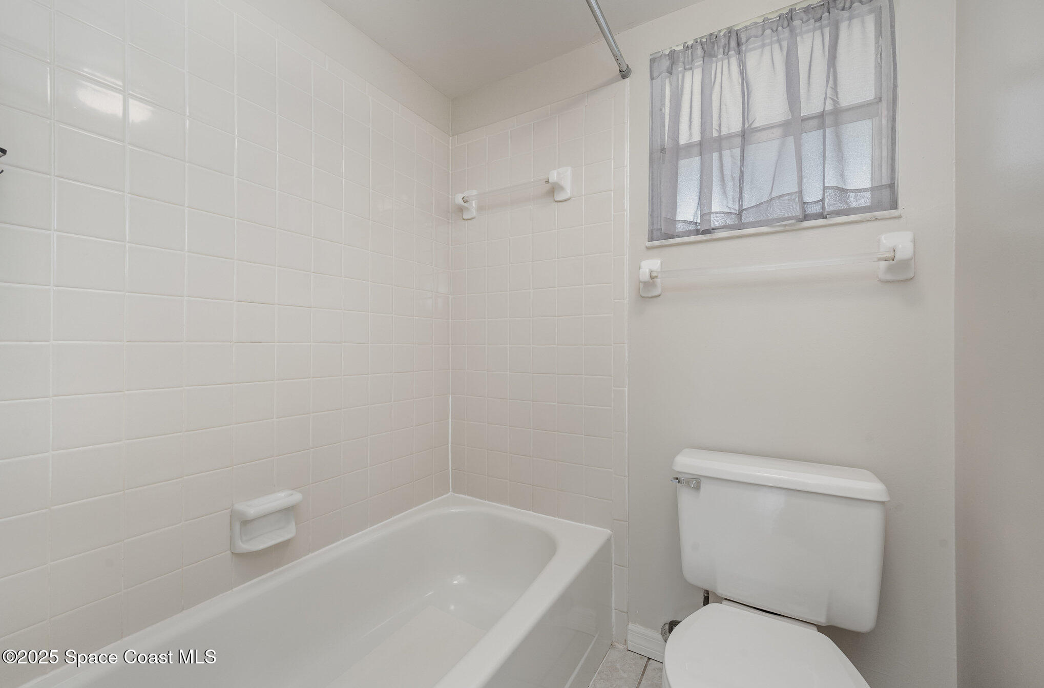 2935 Thrush Drive, Unit 144 Melbourne, FL 32935 - Photo 11 of 17 a white toilet sitting next to a bath tub