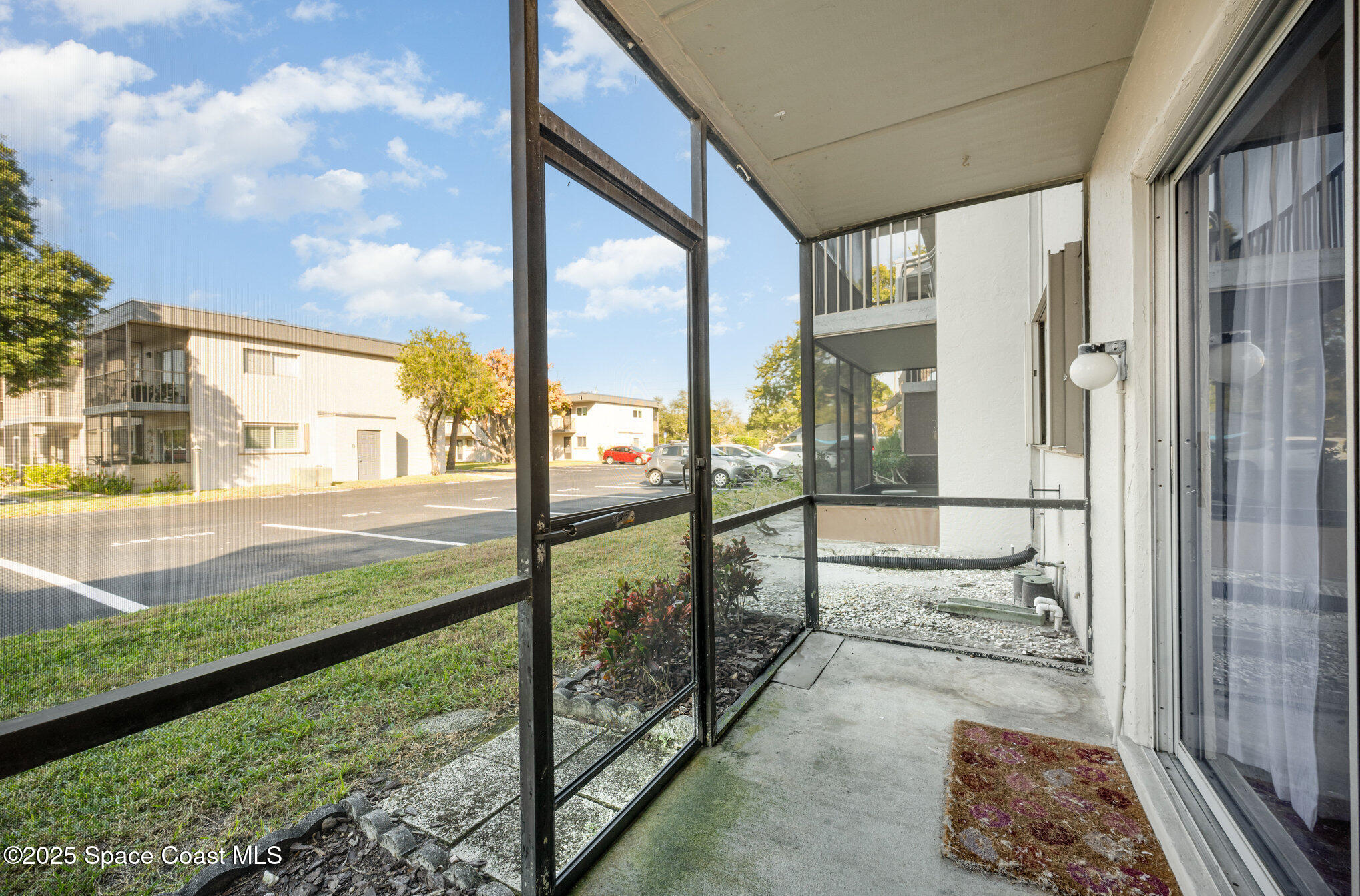 2935 Thrush Drive, Unit 144 Melbourne, FL 32935 - Photo 16 of 17 a view of a porch with a floor to ceiling window next to a yard