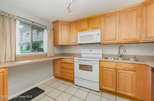 a kitchen with granite countertop cabinets stainless steel appliances a sink and a window