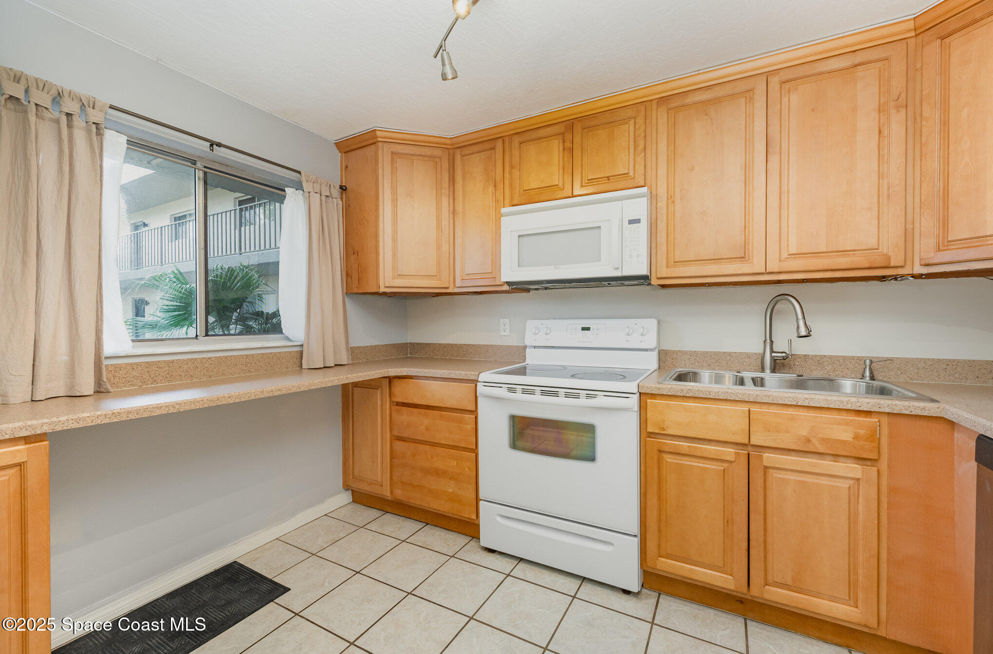 2935 Thrush Drive, Unit 144 Melbourne, FL 32935 - Photo 3 of 17 a kitchen with granite countertop cabinets stainless steel appliances a sink and a window