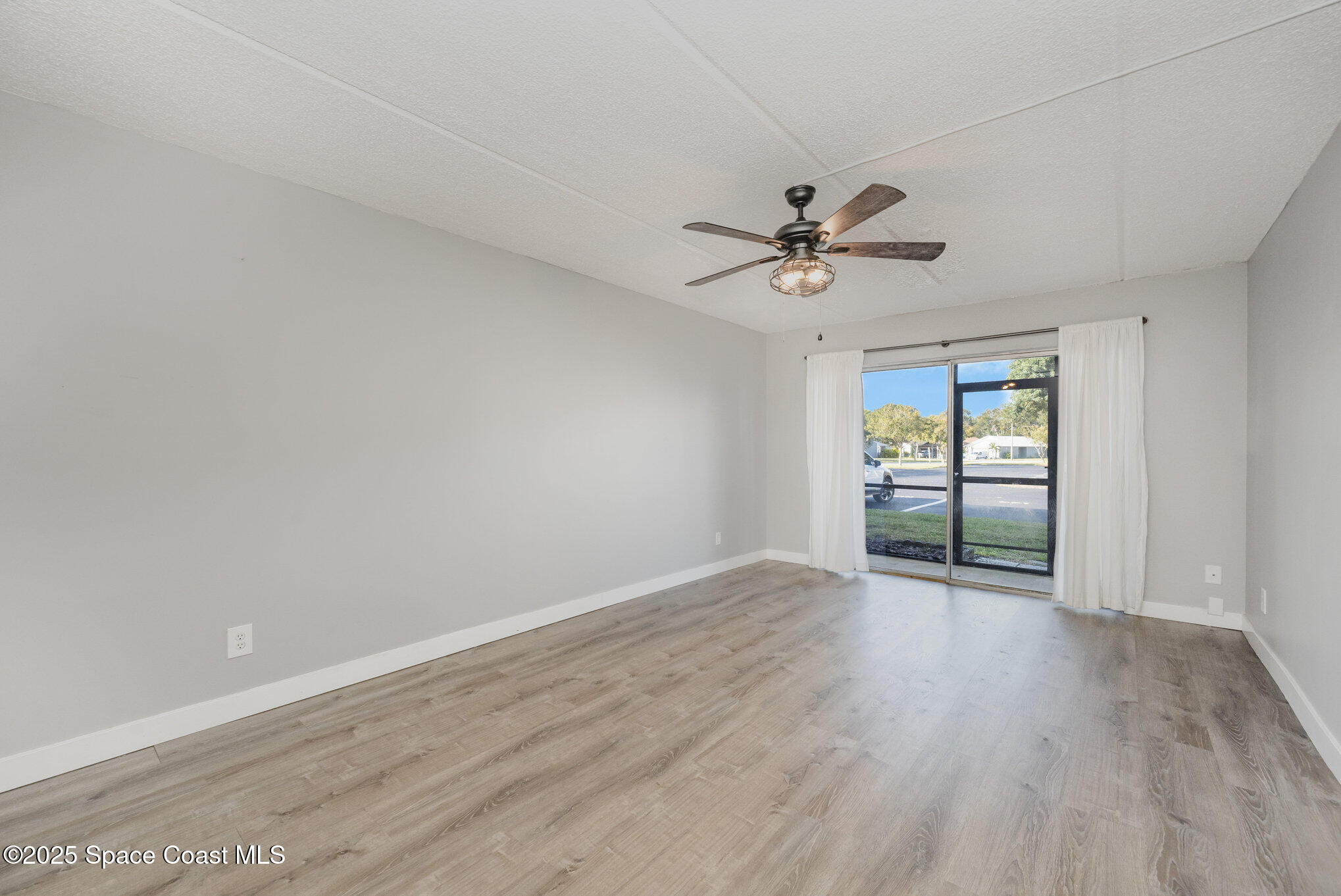 2935 Thrush Drive, Unit 144 Melbourne, FL 32935 - Photo 8 of 17 a view of an empty room with window and wooden floor