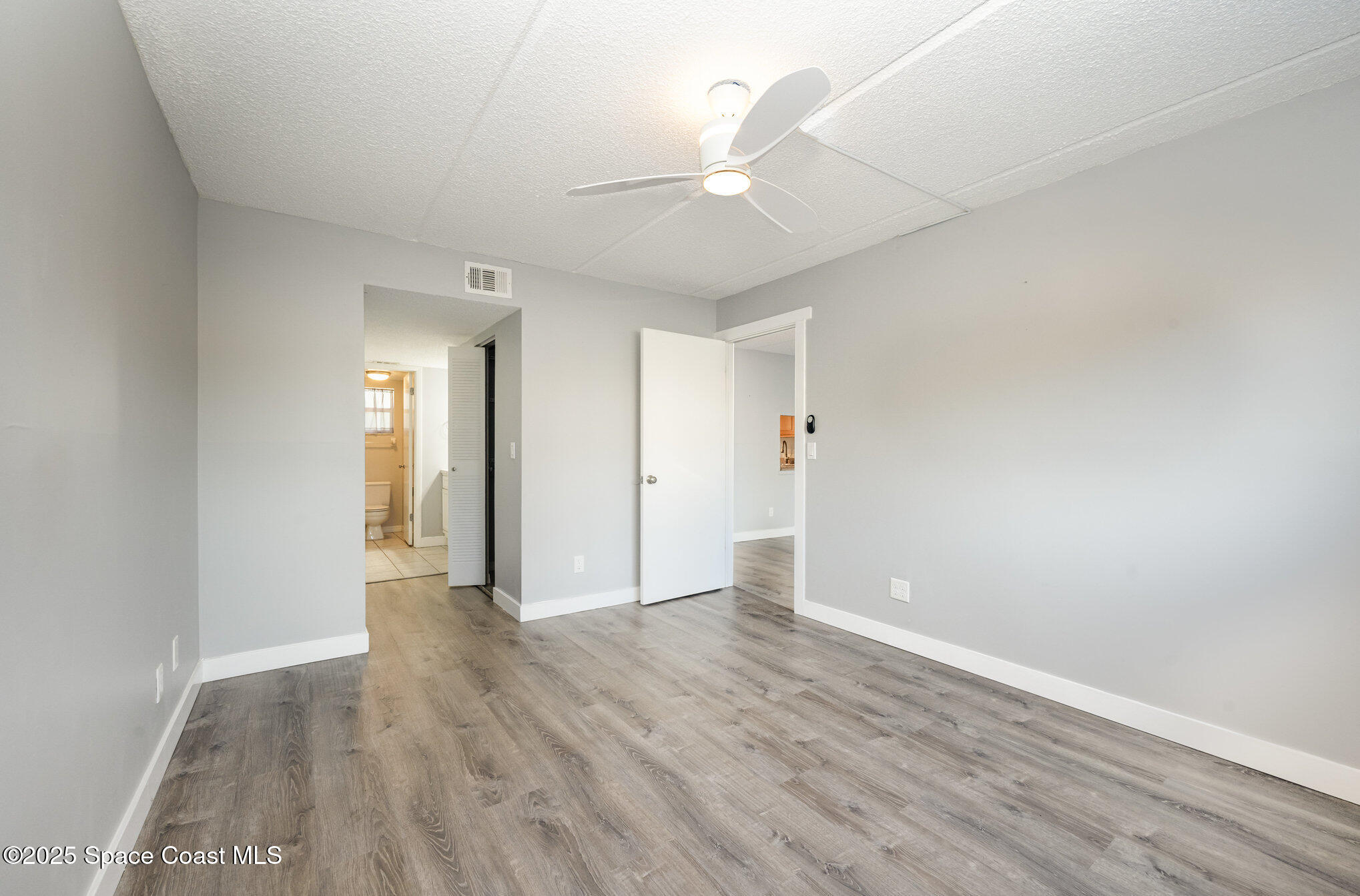 2935 Thrush Drive, Unit 144 Melbourne, FL 32935 - Photo 9 of 17 wooden floor in an empty room with a window
