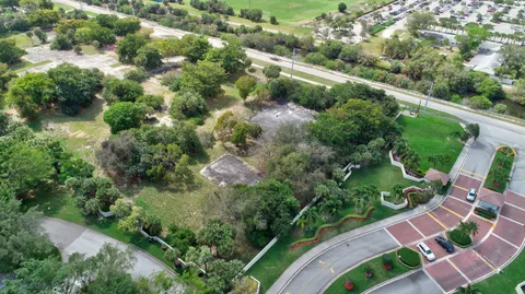 an aerial view of residential houses with outdoor space and trees