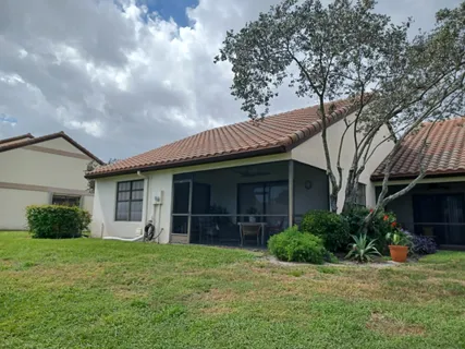 a view of a house with brick walls and a yard with potted plants