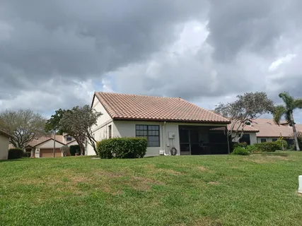 a front view of a house with a garden and trees