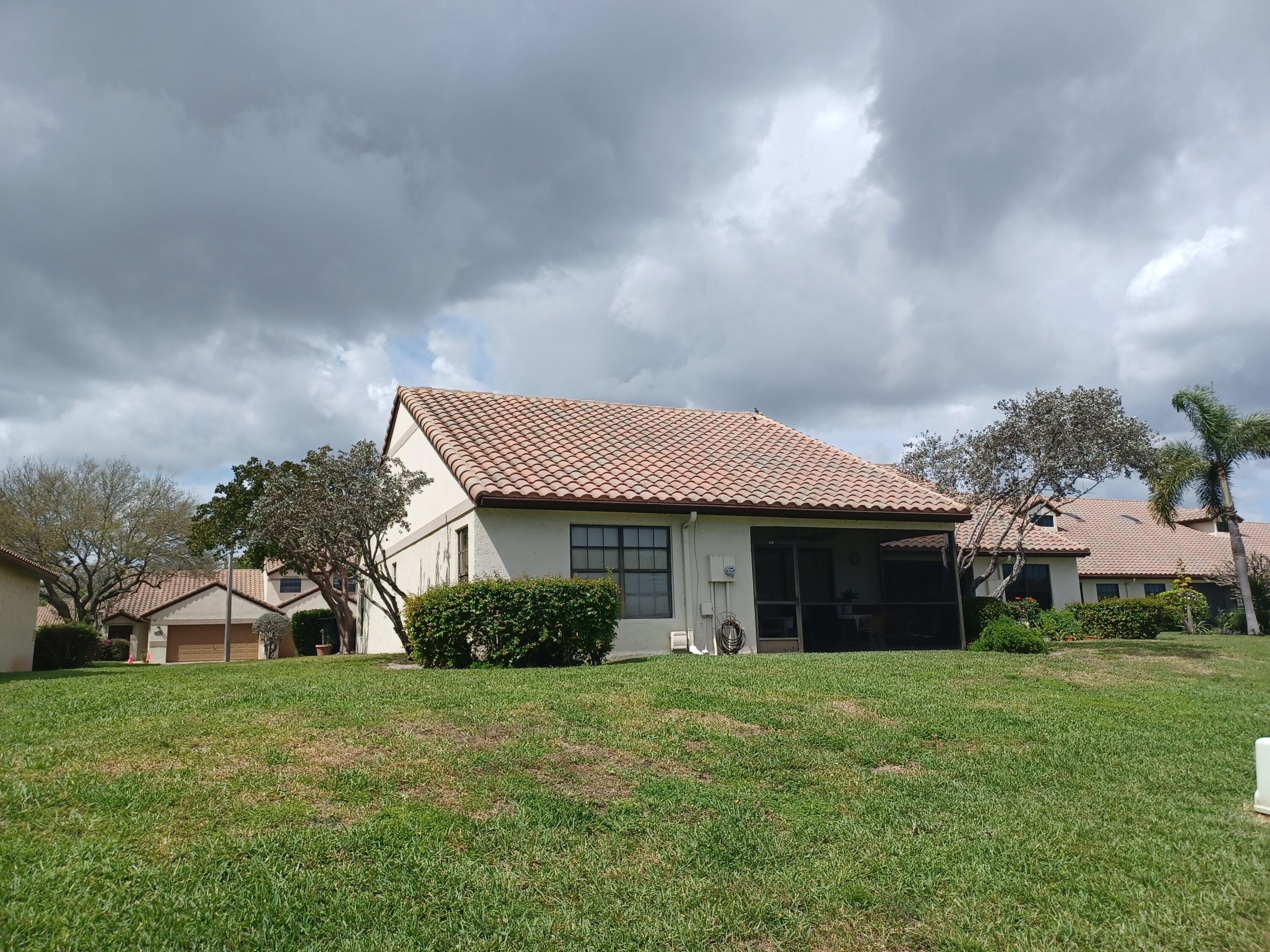 338 Eastwood Terrace Boca Raton, FL 33431 - Photo 7 of 31 a front view of a house with a garden and trees